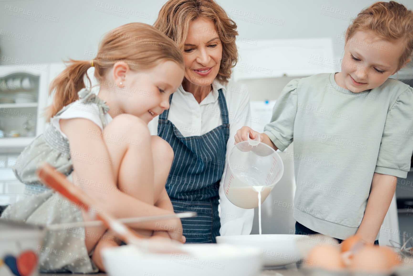 Buy stock photo Grandmother, help and children with jug, measuring and learning in kitchen, house or home for pastry or dessert cake. Happy, family and teaching cooking kids baking pudding, cookies or bakery recipe