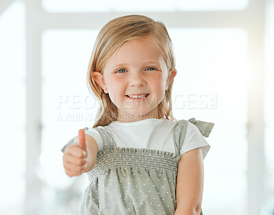 Buy stock photo Shot of an adorable little girl standing alone at home and showing a thumbs up