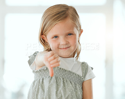 Buy stock photo Girl, portrait and thumbs down in home for dislike, opinion and fail with rejection, review and feedback. Female child, face and choice for disappointed, vote and decision with negative emoji sign