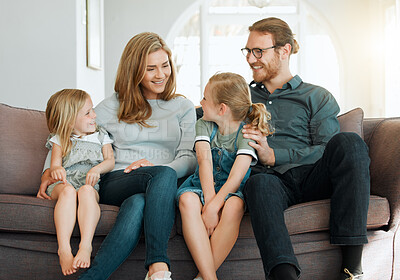 Buy stock photo Shot of young family sitting on the sofa at home together and bonding