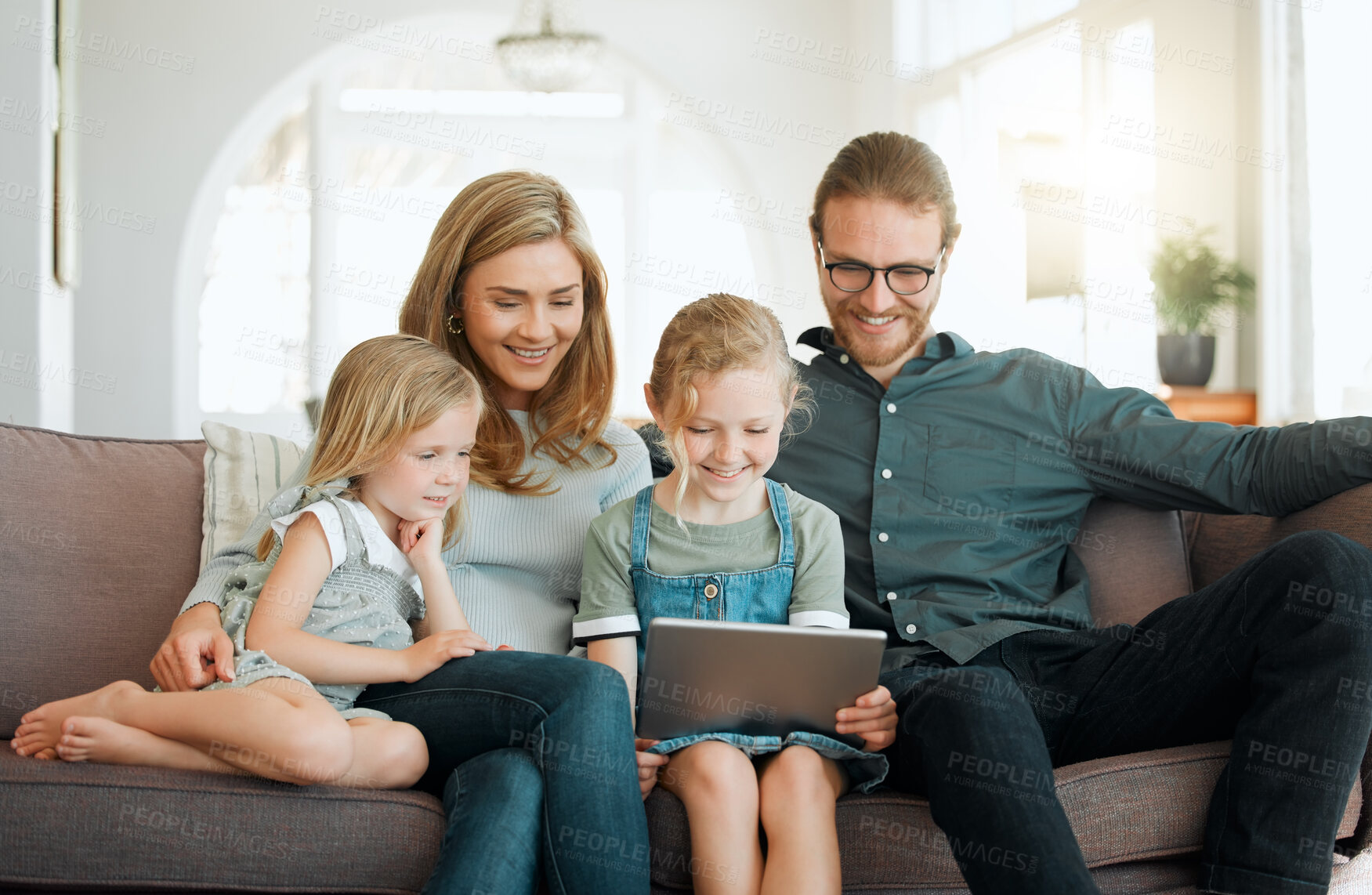 Buy stock photo Love, smile and tablet with family on sofa in living room of home for bonding together. Happy, relax or streaming with mother, father and girl children in apartment for development or growth