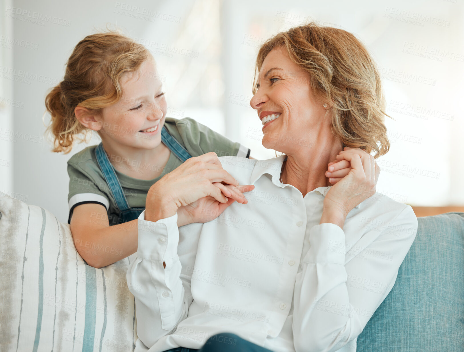 Buy stock photo Girl, grandmother and relax on sofa with smile for bonding, care and embrace on weekend with childhood love. Grandma, kid and happy together in family house with hug, affection and laughing on couch.