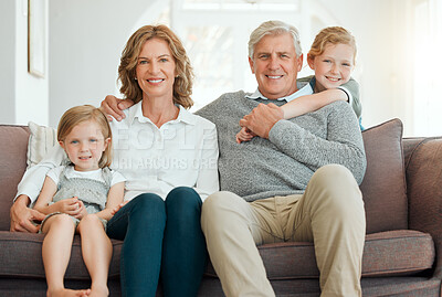 Buy stock photo Shot of a senior couple sitting on the sofa together and bonding with their grandchildren