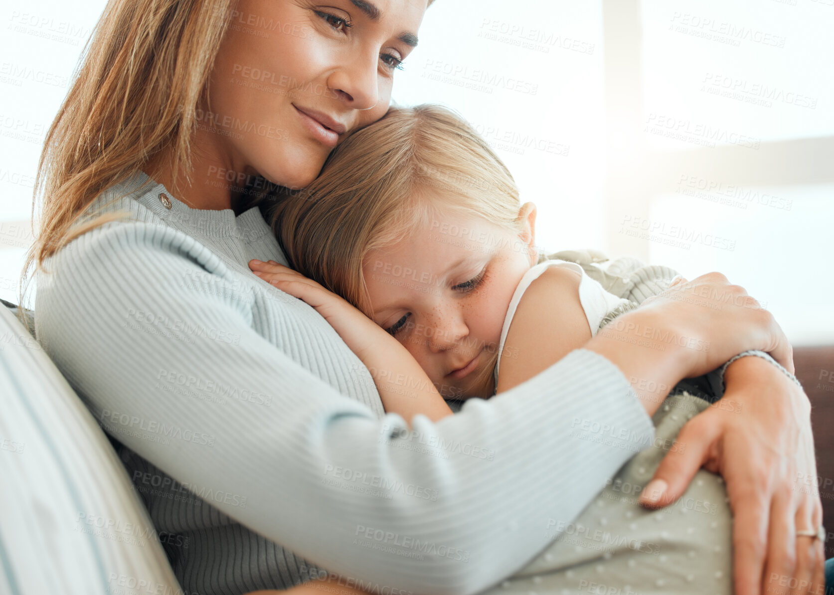 Buy stock photo Shot of an adorable little girl cuddled up to her mother during a day at home