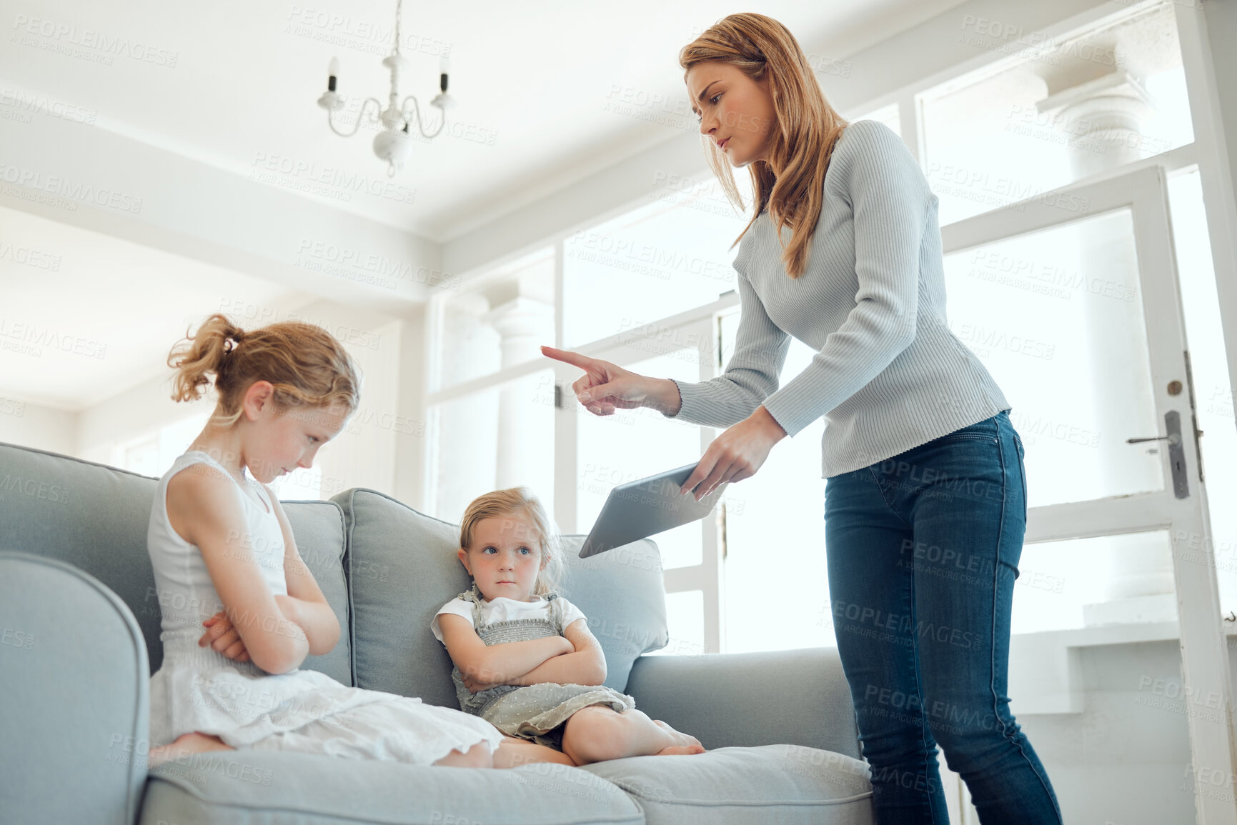 Buy stock photo Tablet, online safety and mother scolding girl child on sofa in living room of home for development. Discipline, social media and technology with parent teaching lesson to daughter in apartment