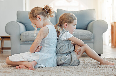 Buy stock photo Shot of two little girls sitting back to back and looking angry at home