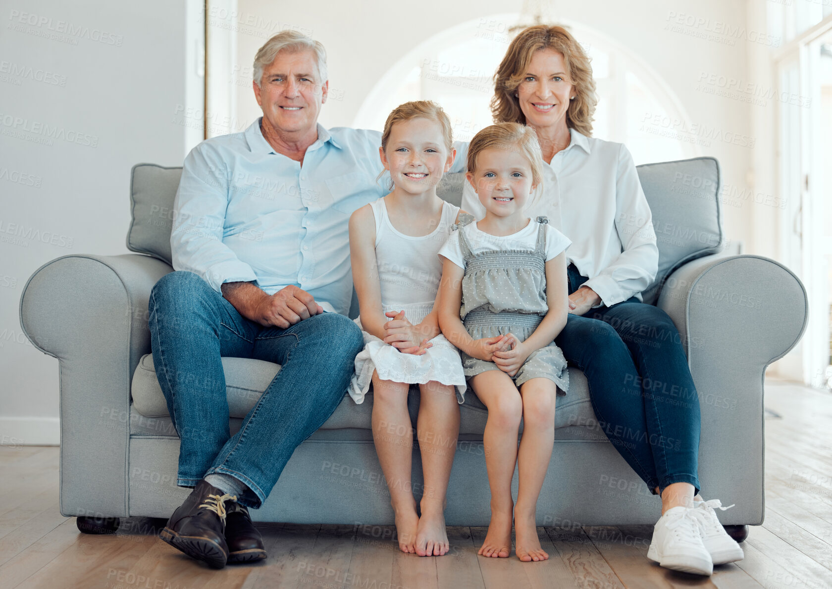 Buy stock photo Shot of grandparents bonding with their grandchildren on a sofa at home