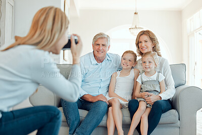 Buy stock photo Shot of grandparents bonding with their grandchildren on a sofa at home and getting their picture taken