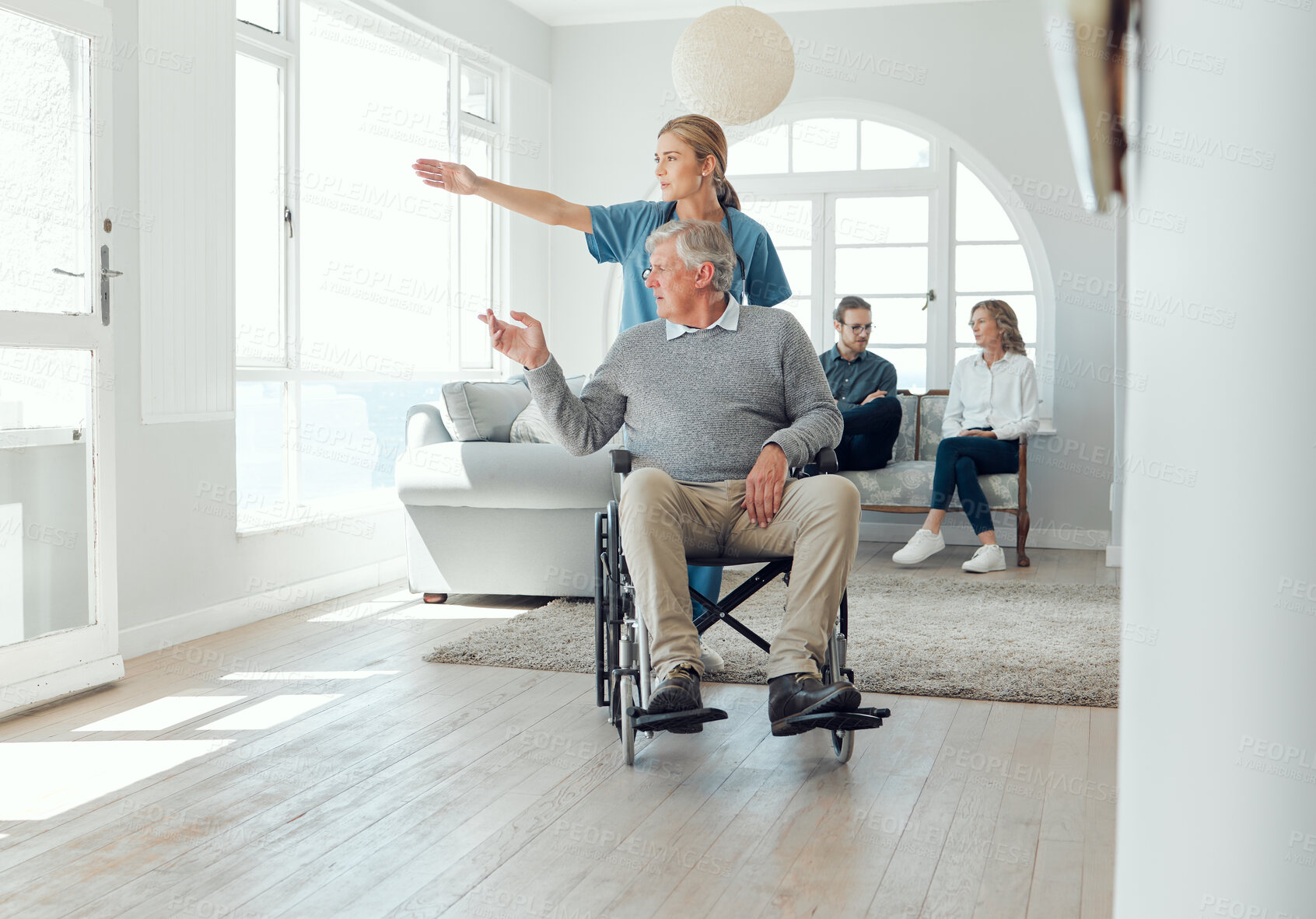 Buy stock photo Shot of a young nurse caring for an older man in a wheelchair