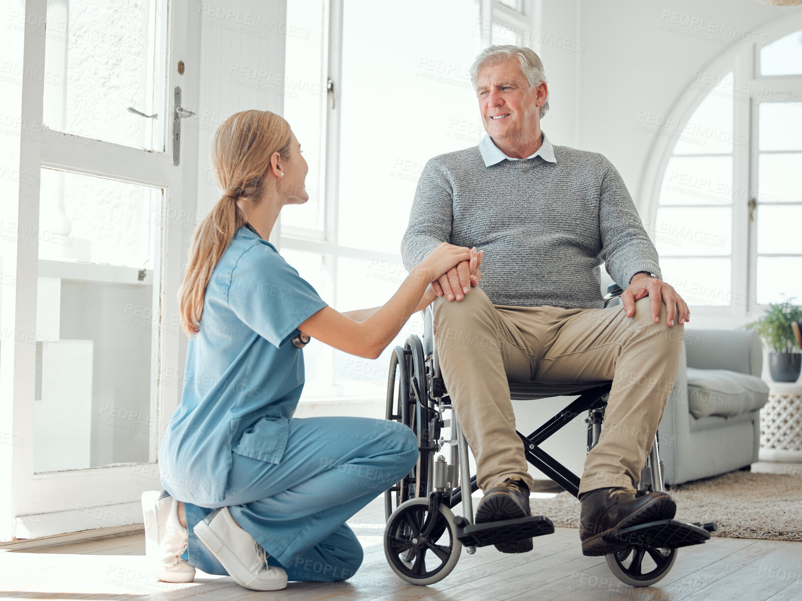 Buy stock photo Shot of a young nurse caring for an older man in a wheelchair