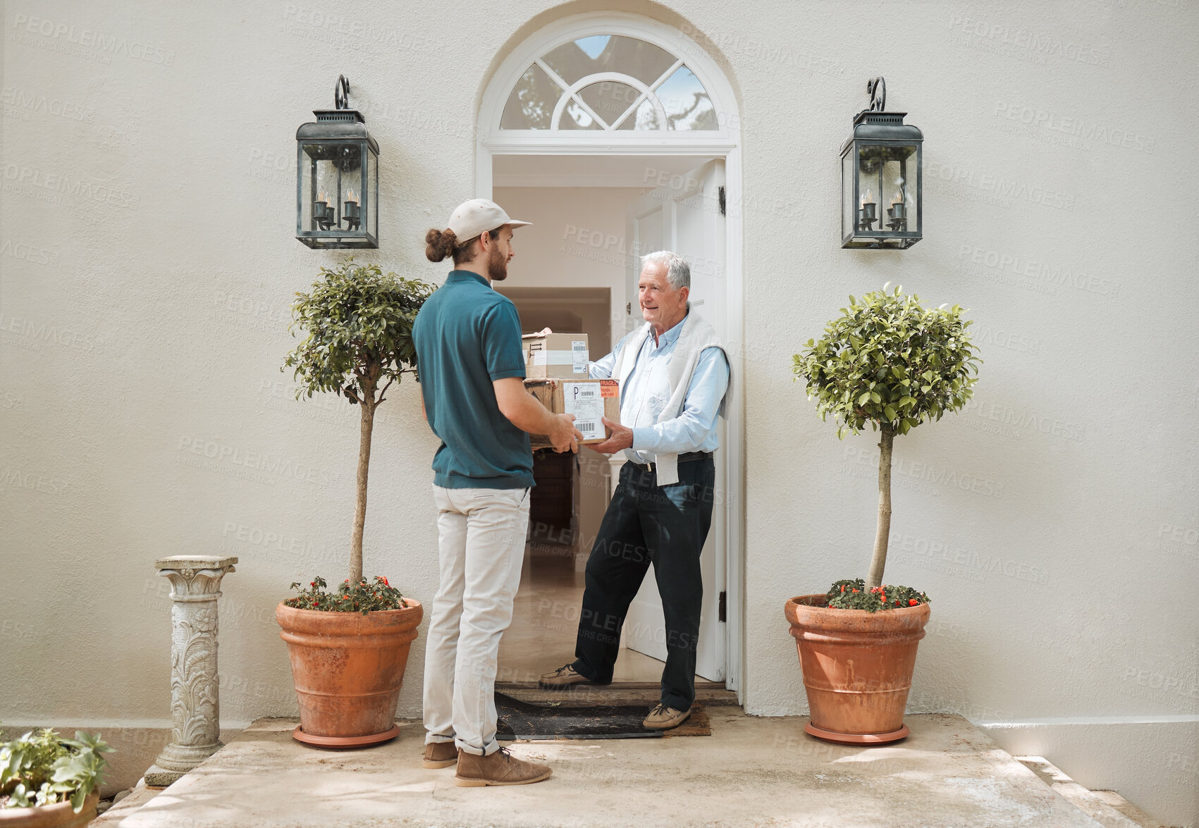 Buy stock photo Shot of a senior man receiving his delivery from the courier