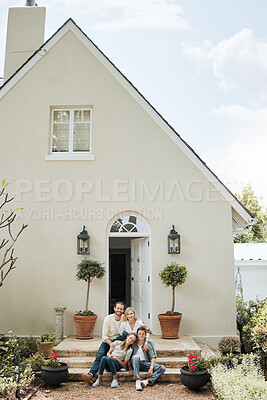 Buy stock photo Shot of a couple and their two children sitting in front of their house