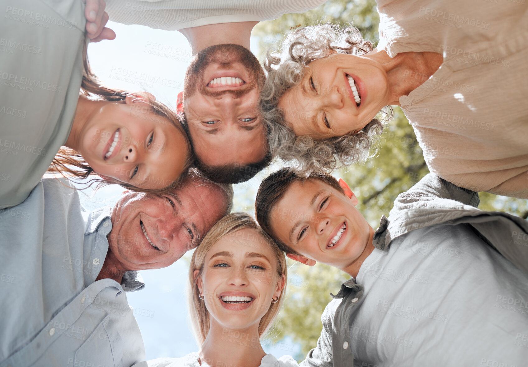 Buy stock photo Shot of a multi-generational family standing together in a huddle