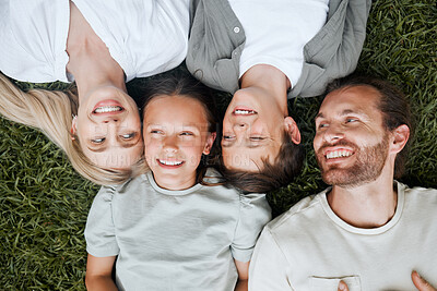 Buy stock photo Shot of a young couple lying outside with their two children