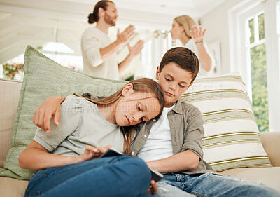 Buy stock photo Shot of a boy comforting his sister while their parents argue in the background