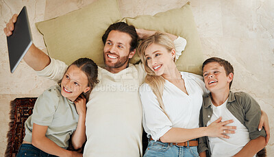 Buy stock photo Shot of a young family using a digital tablet to take selfies at home