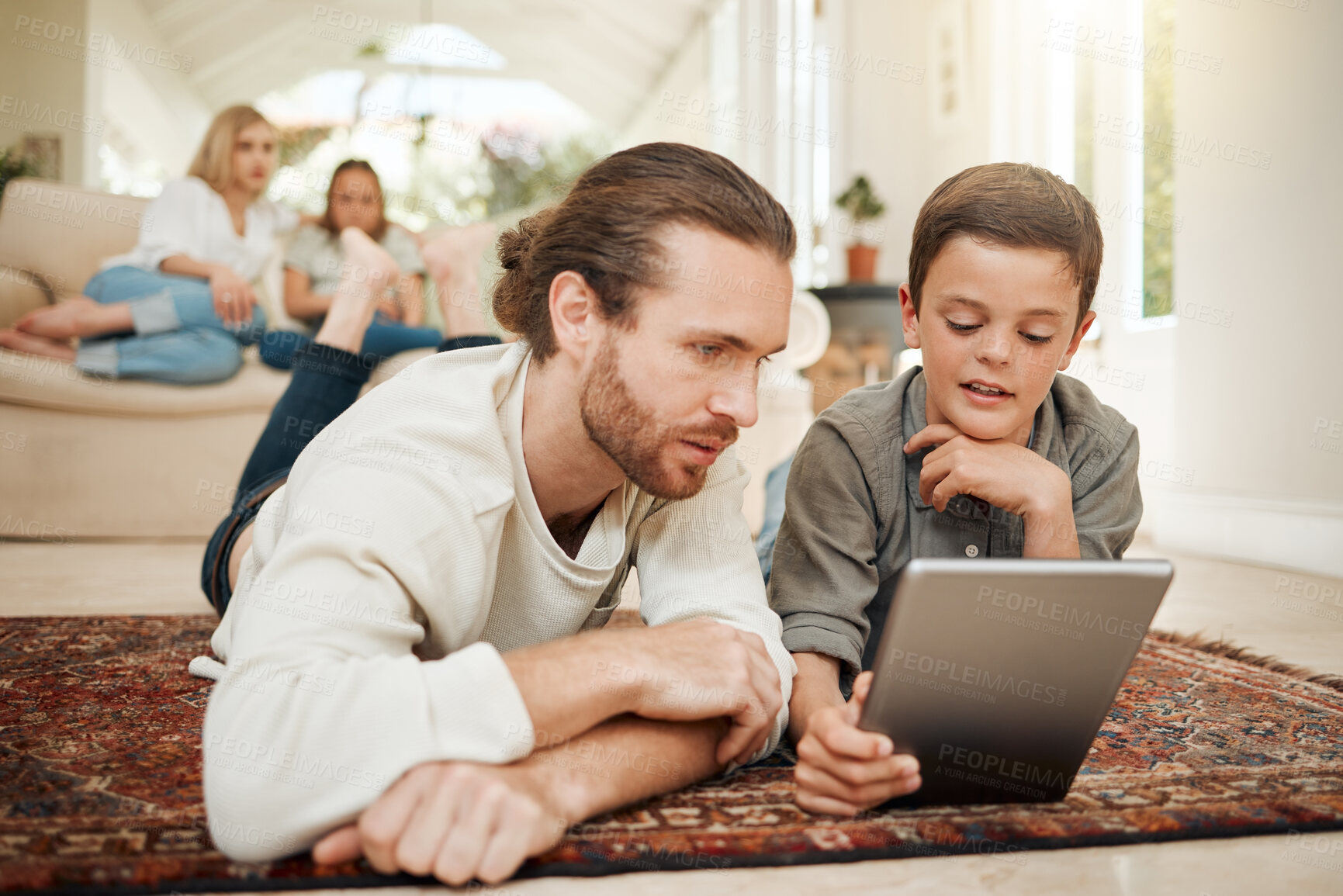 Buy stock photo Shot of a young father spending time with his son while they use a digital tablet