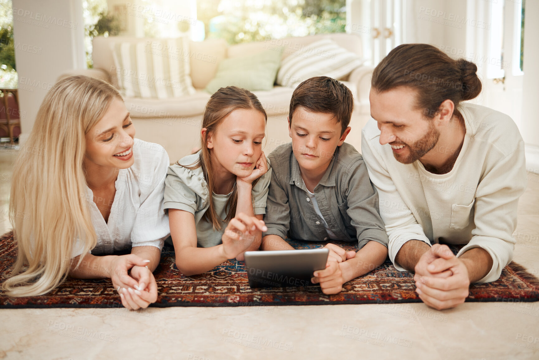 Buy stock photo Family, children and tablet with internet, app and parents watching cartoon on living room floor together. Movies, kids and subscription with mother, father and siblings bonding at home in lounge