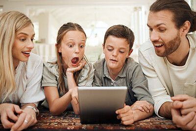 Buy stock photo Shot of a young family spending time together at home while using a digital tablet