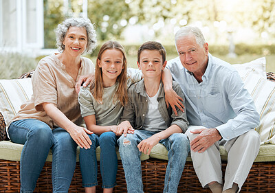 Buy stock photo Shot of a senior couple sitting outside with their two grandchildren