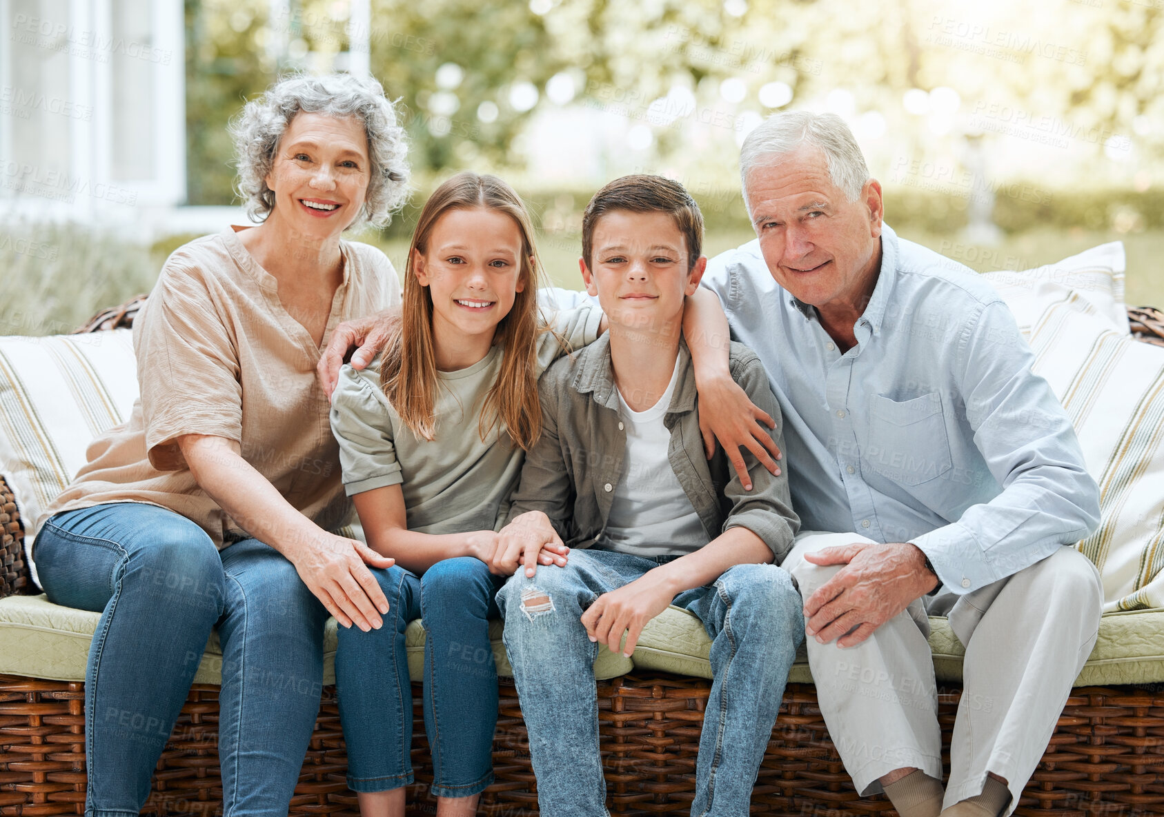 Buy stock photo Grandparents, kids and smile in patio on sofa at home for bonding, support and care in England. People, family and outside with happy on portrait on visit as babysitter for break, relax and rest