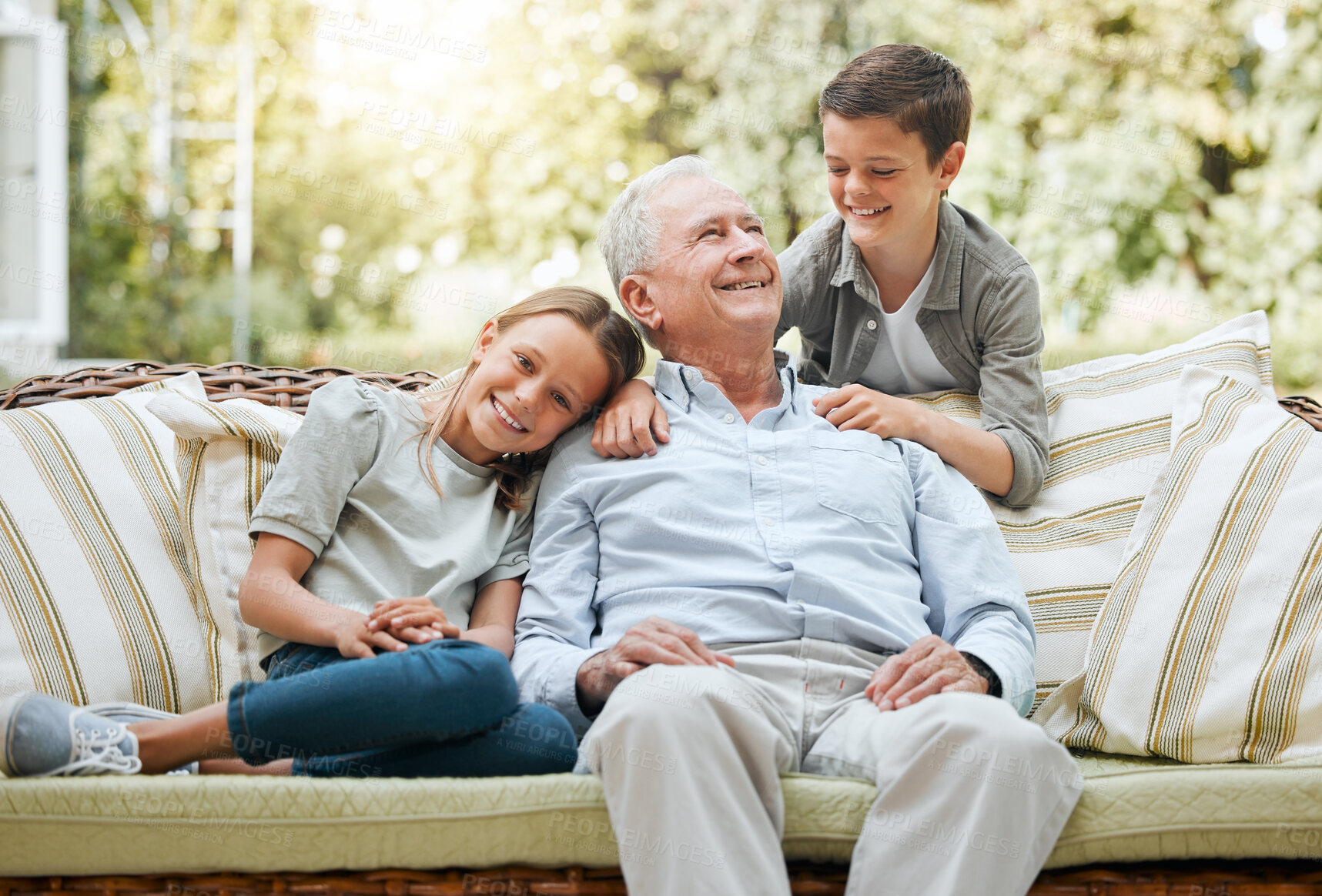 Buy stock photo Grandfather, kids and happy in patio on couch at home for bonding, support and care. People, family and outside with smile or laugh on visit as babysitter for break, relax and rest on sofa for fun