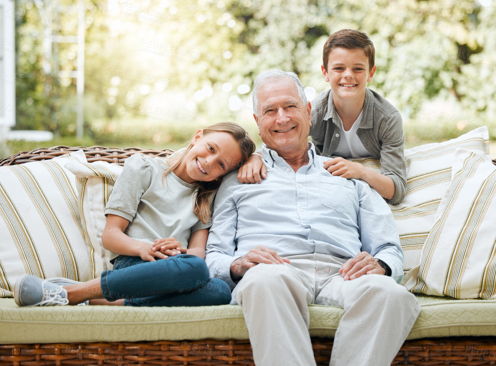 Buy stock photo Grandfather, kids and smile in patio on sofa at home for bonding, support and care in England. People, family and outside with happy on portrait on visit as babysitter for break, relax and rest