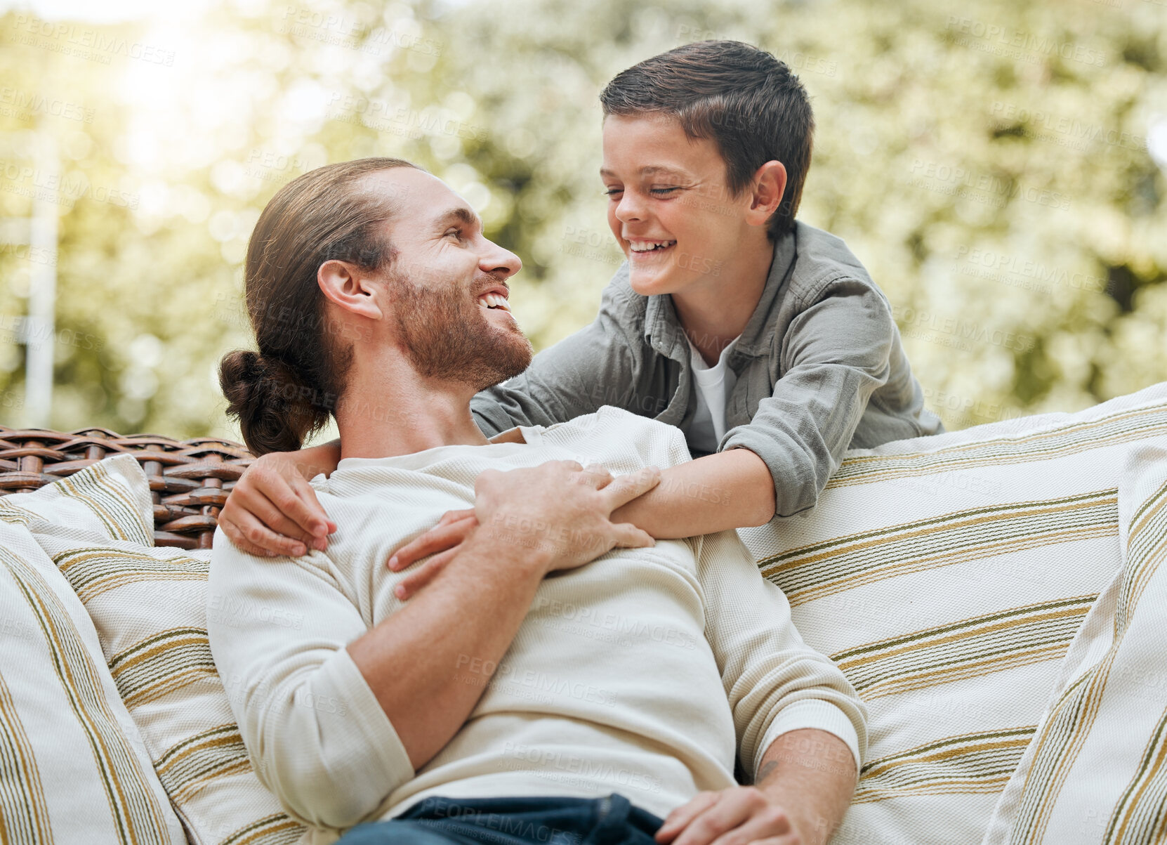 Buy stock photo Father, boy and smile in patio on couch at home for bonding, support and care. People, parent and happy or laughing outside with kid or son for break, relax and rest on sofa with love and trust 