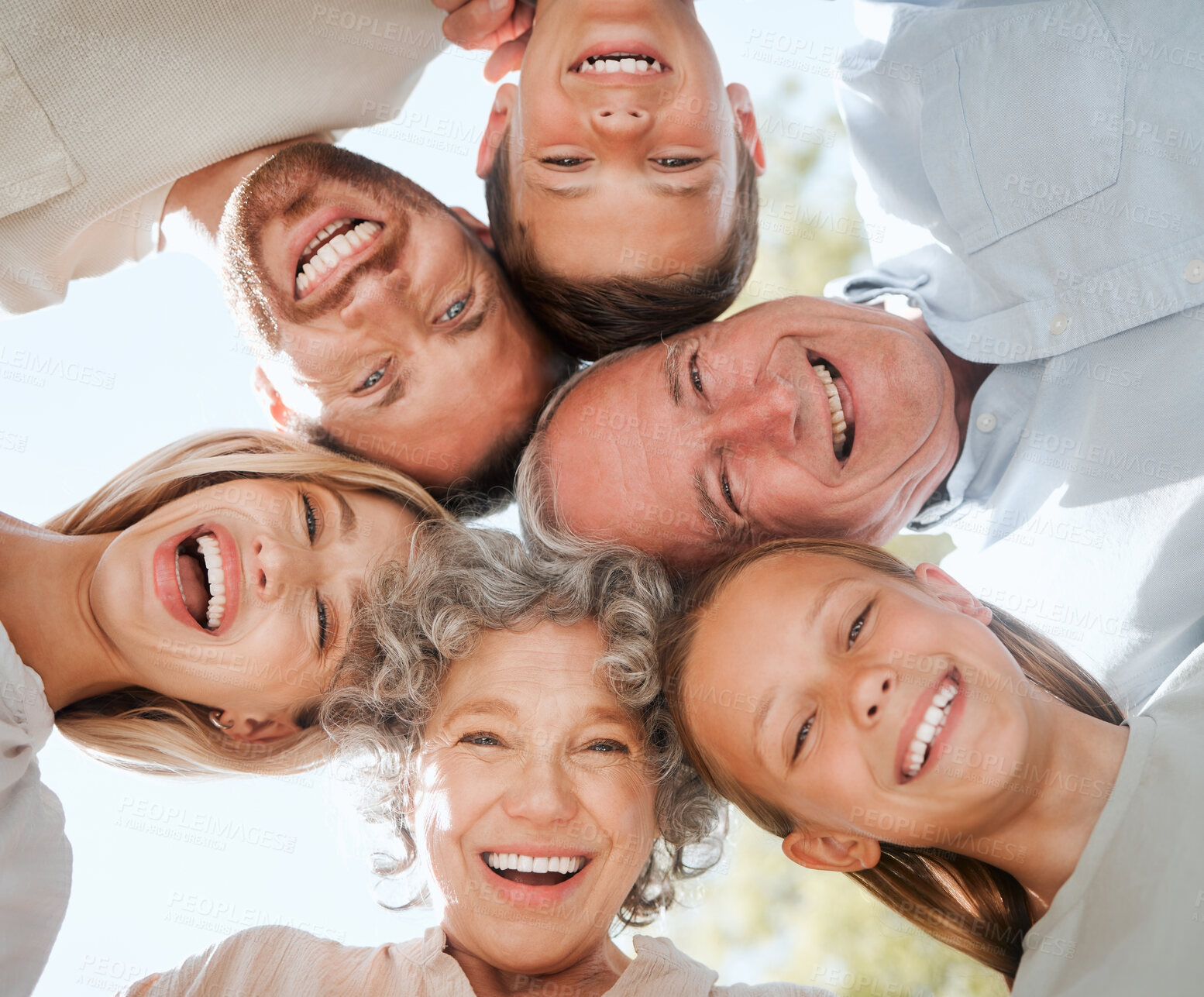 Buy stock photo Happy family, hug and smile for generation, community or support together on blue sky. Below portrait of grandparents, parents and children huddle for vacation bonding for holiday break in park