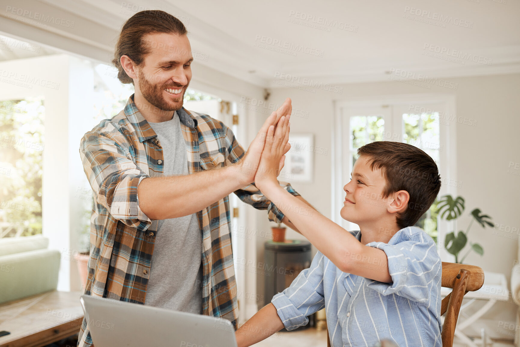 Buy stock photo Shot of a father helping his son with homework at the kitchen table at home