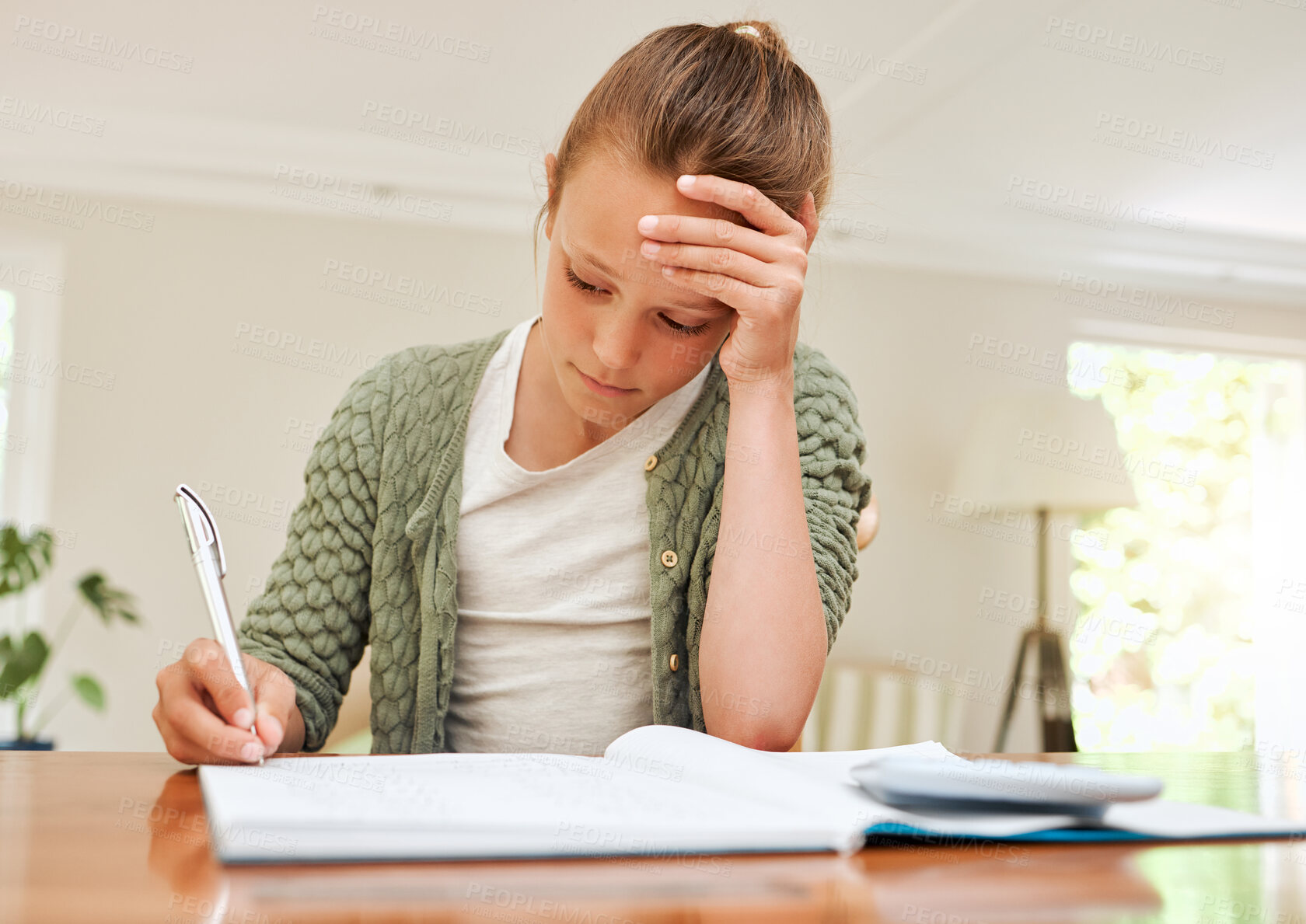 Buy stock photo Shot of a young girl doing her homework at the kitchen table at home