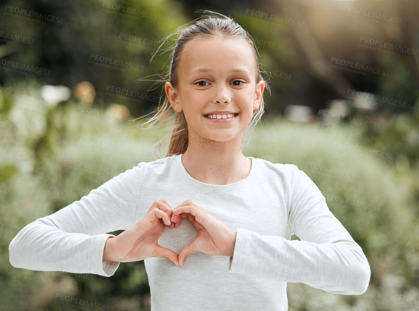 Buy stock photo Happy girl, child and outdoor heart hands in portrait, kindness and symbol for love or care. Female person, thank you icon and show sign for motivation in nature, Canada and emoji for positive review