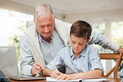 Buy stock photo Shot of a grandfather helping his grandchild with homework at home