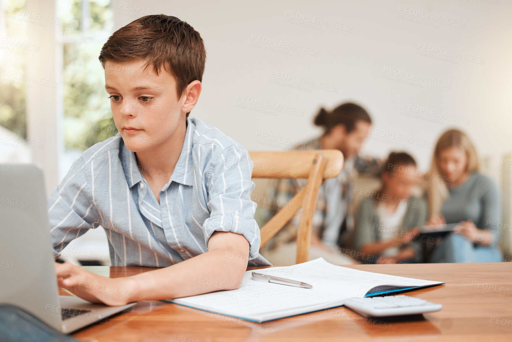 Buy stock photo Shot of a young boy doing his homework at the kitchen table at home