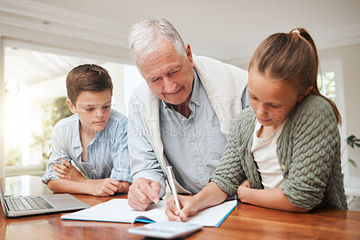 Buy stock photo Shot of a grandfather helping his grandkids with homework at home