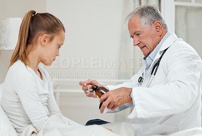 Buy stock photo Shot of a doctor giving a little girl some medicine at home