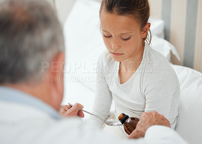 Buy stock photo Shot of a doctor giving a little girl some medicine at home