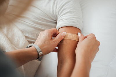 Buy stock photo Shot of a unrecognizable woman putting a plaster on her daughter