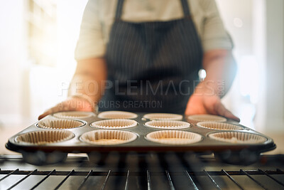 Buy stock photo Cropped shot of a woman taking a baking tray out of the oven