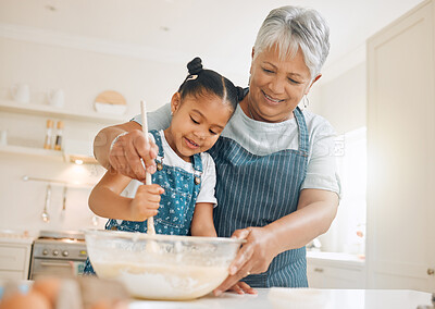 Buy stock photo Shot of a little girl baking with her grandmother at home