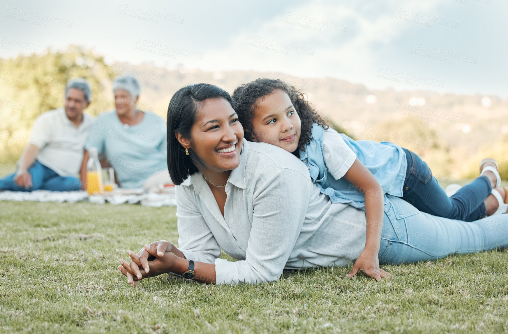 Buy stock photo Shot of a mother and daughter laying on the grass in a park