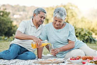 Buy stock photo Shot of a senior couple enjoying a picnic outside