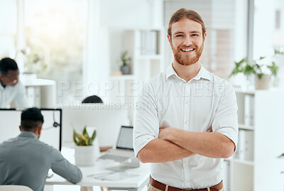 Buy stock photo Cropped portrait of a handsome young businessman standing with his arms folded in the office