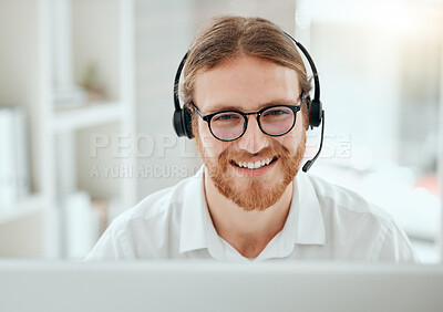 Buy stock photo Cropped shot of a handsome young male call center agent working at his desk in the office