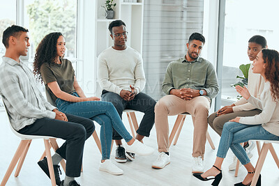 Buy stock photo Shot of a diverse group of people sitting together and talking during group therapy