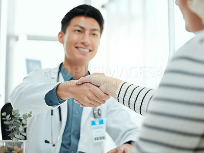 Buy stock photo Shot of a mature doctor sitting in the clinic and shaking hands with his patient