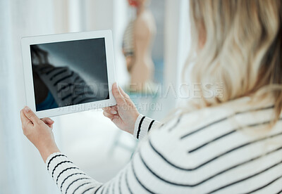 Buy stock photo Shot of an unrecognisable woman using a digital tablet at home