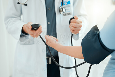 Buy stock photo Shot of a doctor using a blood pressure gauge during a checkup with his pregnant patient