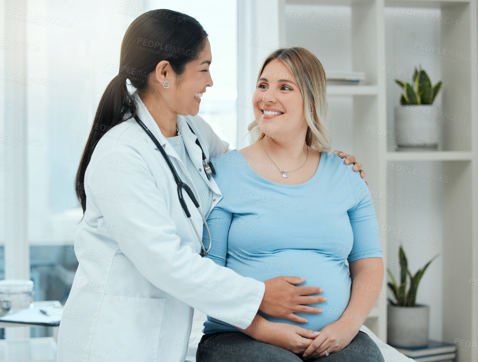 Buy stock photo Healthcare, comfort and doctor with a pregnant woman in a clinic touching her belly for support. Maternity, wellness and female nurse hugging a patient with pregnancy during a prenatal consultation.