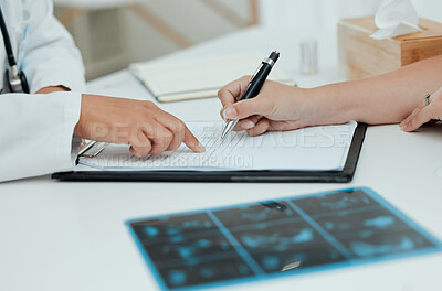 Buy stock photo Shot of a unrecognizable woman filling in paperwork during a consultation with a doctor
